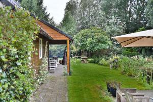 un jardín con una pequeña casa con patio en B&B Houtstee en Veendam