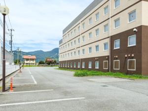 um estacionamento vazio em frente a um prédio em Comfort Inn Kofu Isawa em Fuefuki