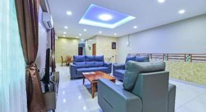 a living room with blue chairs and a table at OYO 90522 Alma Sweet Home in Juru +42 photos