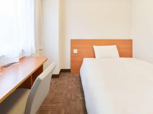 um quarto com uma cama branca e uma escrivaninha e uma cama sidx sidx em Comfort Inn Ichinoseki Inter em Ichinoseki