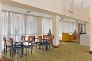 a dining room with a table and chairs and a couch at Clarion Hotel & Conference Center Lansing West in Lansing