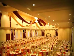 um grande salão de banquetes cheio de mesas e cadeiras em Rama Garden Hotel em Palu