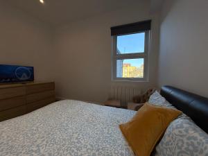 a bedroom with a bed and a television and a window at Belin Stay in Hackbridge +15 photos