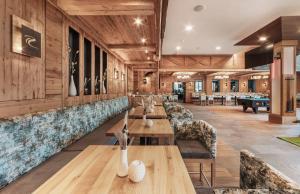 un ristorante con pareti in legno, tavoli e divani di SKI - GOLF - WELLNESS Hotel Riml a Hochgurgl