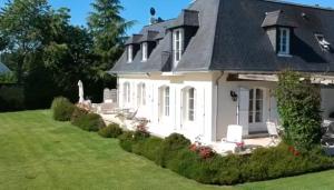 ein weißes Haus mit einem schwarzen Dach in der Unterkunft L Oisette in Epiniac