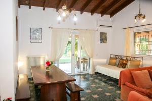 Country House Filippos - Private Garden Escape في Katarrákhion: غرفة نوم بها سرير وطاولة وأريكة