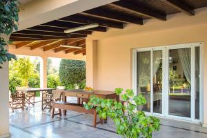 Country House Filippos - Private Garden Escape في Katarrákhion: فناء مع طاولة وكراسي على منزل +30 صورة