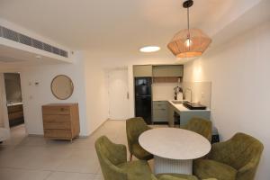 a kitchen and dining room with a table and chairs at Sweet Sea Side Eilat - סוויט סי סייד, אילת in Eilat