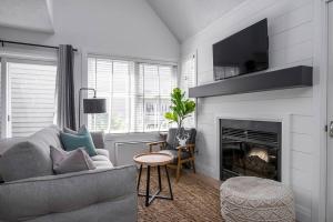 een woonkamer met een bank en een open haard bij Arrowhead Retreat Ski-In-Out Pool Shuttle in Blue Mountains