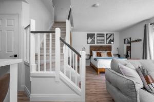 een witte slaapkamer met een bed en een trap bij Arrowhead Retreat Ski-In-Out Pool Shuttle in Blue Mountains