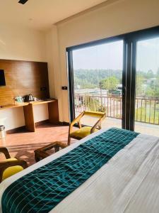 een hotelkamer met een bed en een groot raam bij Chitralekha Boutique Resort in Rājpur +113 foto's