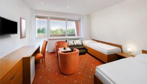 um quarto de hotel com uma cama e uma escrivaninha em Hotel Academia em Tatranská Lomnica mais 17 fotografias