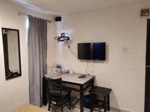 a room with a table with chairs and a television on the wall at Vitro Hotel in Johor Bahru