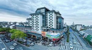 a large building on a busy city street with cars at Vienna Hotel Yangzhou Yangzhou Slender West Lake Wenchangge in Yangzhou