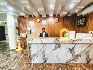哈伊勒روعة أجا للشقق المخدومة的坐在前台里穿着西装的人