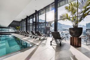 una piscina dell'hotel con sedie e una pianta in vaso di SKI - GOLF - WELLNESS Hotel Riml a Hochgurgl