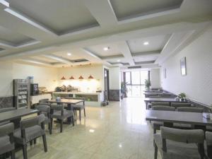 a restaurant with tables and chairs in a room at GreenTree Inn Sichuan Chengdu Airport Road Express Hotel in Chengdu