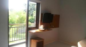 a room with a large window and a television at MANDARI HOTEL SINGARAJA in Singaraja