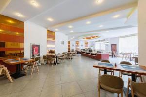 Un comedor con mesas y sillas en un restaurante. en GreenTree Inn JinDeZhen People Square Taoxichuan Wenchuang Street, en Jingdezhen