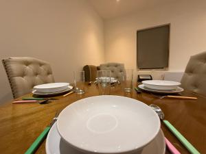 a room with a table with chairs and a screen at Belin Stay in Hackbridge