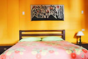 a bedroom with a bed and a painting on the wall at Hostal Timara in Baños