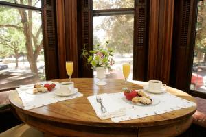 a wooden table with two plates of food and drinks at Morgan State House Inn in Albany