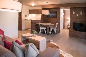 uma sala de estar com um sofá e uma mesa em Ariston Dolomiti Residence em Dobbiaco