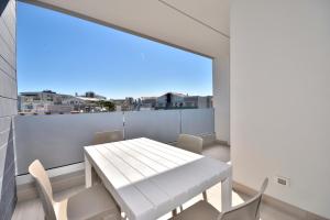 a white table and chairs on a balcony with a view at Condominio Aliante in Bibione