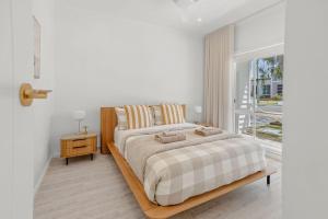 Coastal Waters - Spa, Sleeps 8, Newly Renovated في أوشن غروف: غرفة نوم بيضاء مع سرير كبير ونافذة