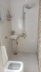 a white bathroom with a sink and a toilet at Private Rooms And Bed Spaces Available In Sohar in Al ‘Awhī