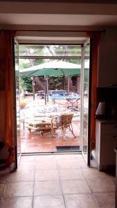 una porta-finestra aperta con tavolo e ombrellone di Resort Siranita a Ercolano