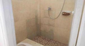 um banheiro com chuveiro e vaso sanitário em SPOT ON 93478 Amanda Residence Syariah em Palimbão mais 48 fotografias