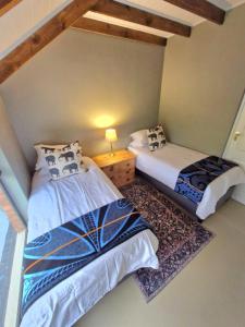 霍维克The Scottage的一间卧室配有两张床,房间铺有地毯