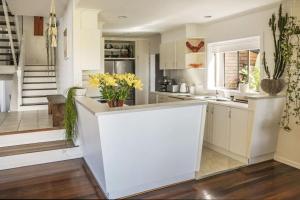 バリナにあるParadise Sands - Oceanstaysの白いキャビネットと黄色い花が並ぶカウンター付きのキッチン +35枚の写真