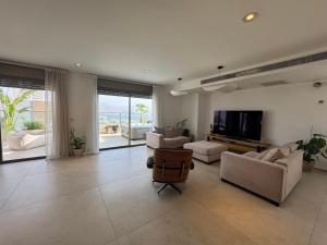 un ampio soggiorno con divani e televisione di פנטהואז אלגריה - Adults only a Eilat