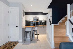 een keuken met witte kasten en een aanrecht met krukken bij Mountainside Escape Ski-In-Out Pool Shuttle in Blue Mountains