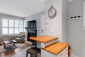 een keuken en een woonkamer met een klok aan de muur bij Mountainside Escape Ski-In-Out Pool Shuttle in Blue Mountains +41 foto's