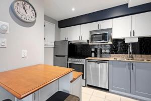 a kitchen with stainless steel appliances and a clock on the wall at Mountainside Escape Ski-In-Out Pool Shuttle in Blue Mountains +41 photos