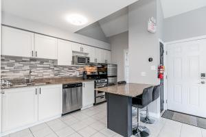 a kitchen with white cabinets and a counter top at Mountain View Ski-In-Out Pool Shuttle to Blue in Blue Mountains +33 photos