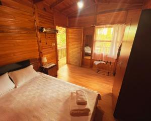 a bedroom with a bed in a wooden cabin at Kybele Nature Life in Edremit
