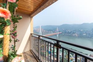 a balcony with a view of a river and a bridge at Guyu B&B in Chongqing