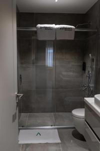 a bathroom with a shower with a green arrow on the floor at Boamonti Residence Sisli Apart in Istanbul +65 photos