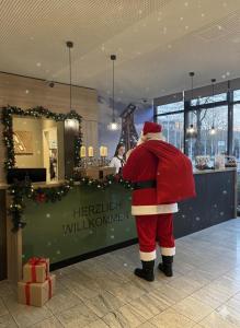 a man dressed as santa claus standing in a store at Mercure Hotel Plaza Essen in Essen