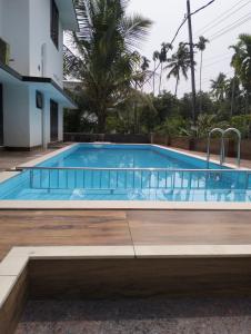a large swimming pool with blue water in a building at Bachan's Casa in Cherai Beach