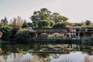 a resort with a pond in front of it at Forum Homini Boutique Hotel in Krugersdorp