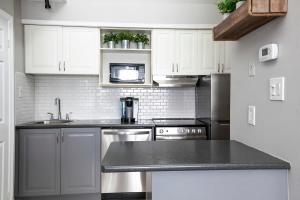 een keuken met witte kasten en een zwart aanrechtblad bij Northern Tranquility Ski-In-Out Pool Shuttle in Blue Mountains