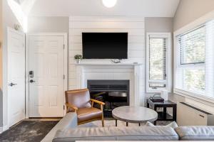 een woonkamer met een bank en een tv op een open haard bij Northern Tranquility Ski-In-Out Pool Shuttle in Blue Mountains