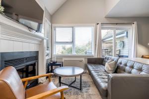 een woonkamer met een bank en een open haard bij Northern Tranquility Ski-In-Out Pool Shuttle in Blue Mountains
