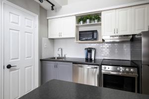 a kitchen with white cabinets and a black counter top at Northern Tranquility Ski-In-Out Pool Shuttle in Blue Mountains