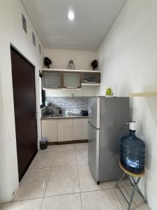 a kitchen with a refrigerator and a table with a water bottle at Pandan de Bali in Ungasan